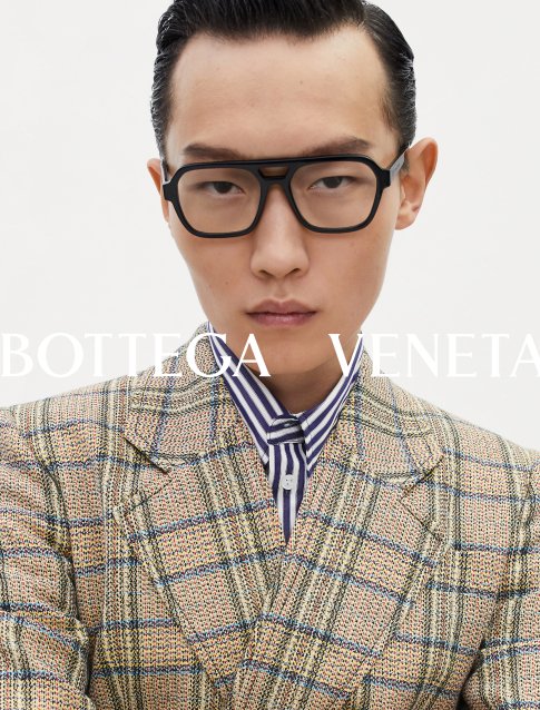 Homme portant des lunettes de luxe modernes, affichant un style personnel audacieux et confiant.